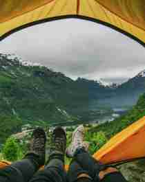 Legs in a tent opening above the Geirangerfjord in Fjord Norway