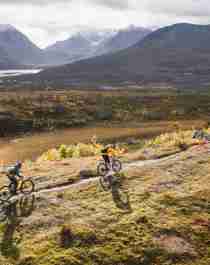 Drie mensen aan het mountainbiken in de regio Lyngenfjord in Noord-Noorwegen, in de bergen