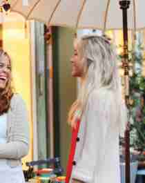 Two girls laughing in front of a store at Bakklandet in Trondheim