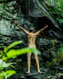 Green travel: A man showering naked under a waterfall in Innerdalen, Norway