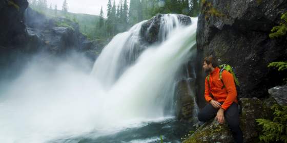 A man looking at Rjukandefossen waterfall in Hemsedal