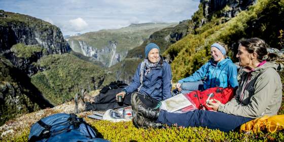 Plan your trip to Norway. People with maps resting in the Aurlandsdalen valley