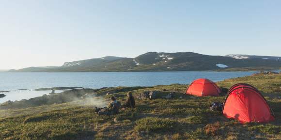 Tents on the shore of a mountain lake.