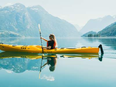 Woman kayaking on Lovatnet, Fjord Norway