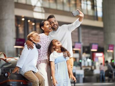 Happy family taking a selfie in an airport after arriving to Norway