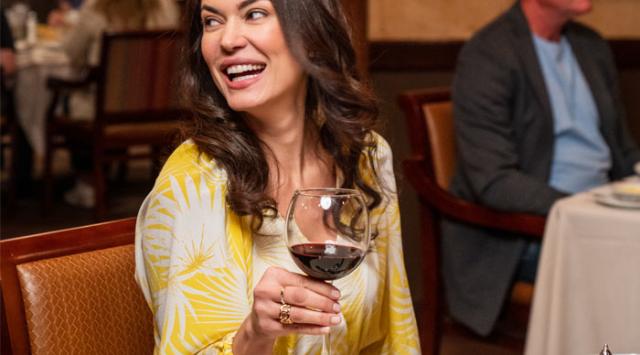 Woman Drinking Wine at Dinner