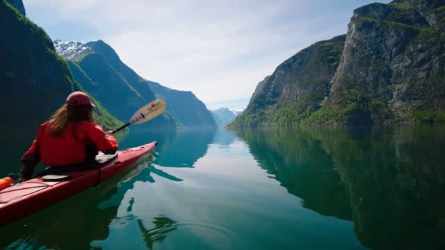 Girl paddling in Fjord Norway