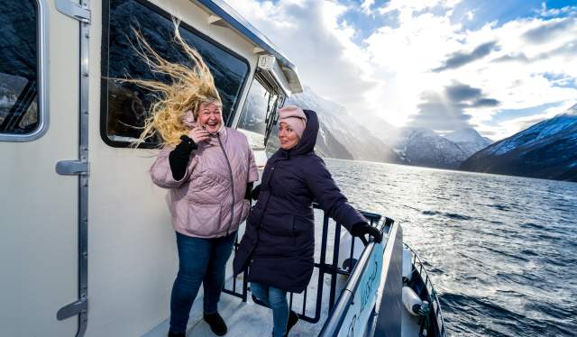 Two women in the wind at Fjordrangers cruise to Geiranger, in winter