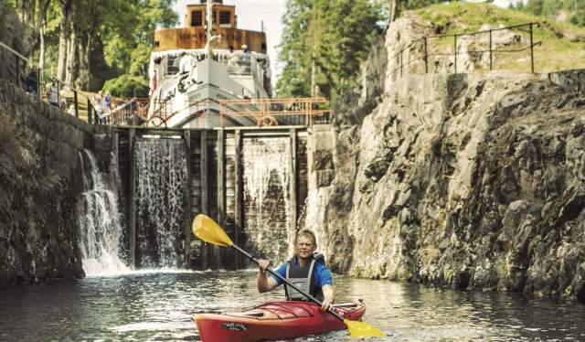 En person paddlar kajak längs Telemarkskanalen, Østlandet (östra Norge)