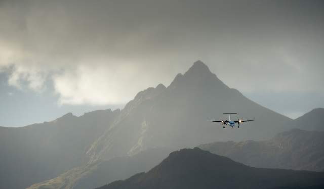 Et fly på vei over de høye fjellene i Lofoten