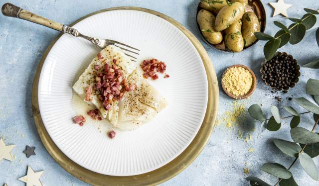 En tallerken med norsk lutefisk, bacon og poteter