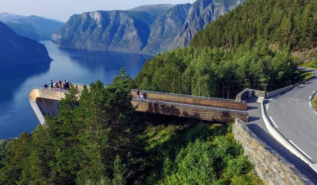 People at Stegastein viewpoint along Norwegian Scenic Route Aurlandsfjellet on a sunny summer day