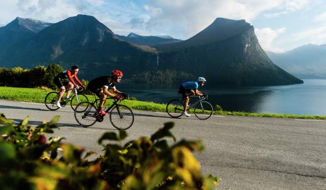 Varias personas practican ciclismo en carretera en Isfjorden, Noruega.
