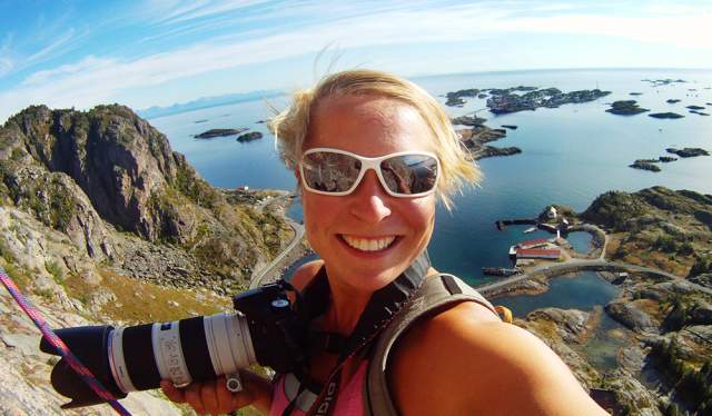 A photographer taking a selfie whilst rock climbing in Lofoten, Norway