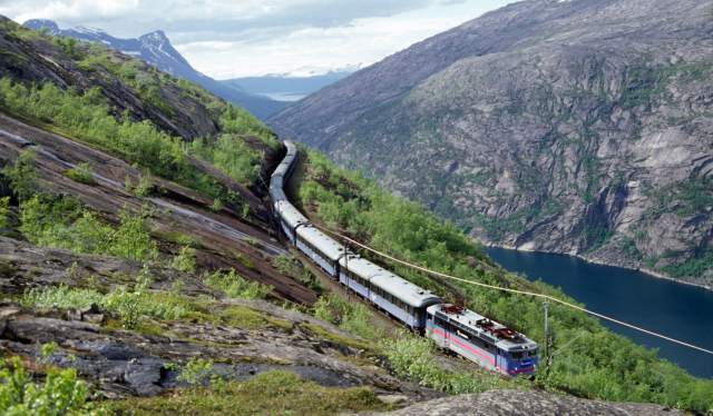 A train on the Ofotbanen in a beautiful river and mountain landscape, Northern Norway