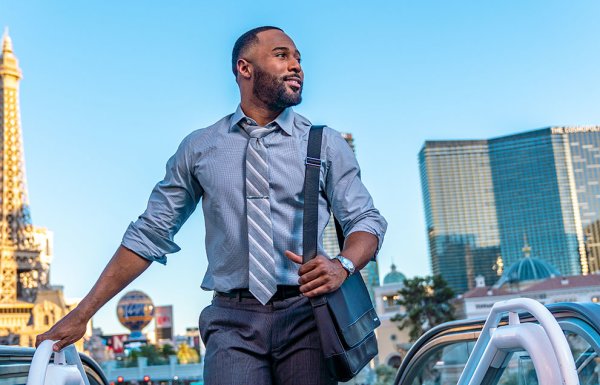 man in business attire at top of escalator in Las Vegas