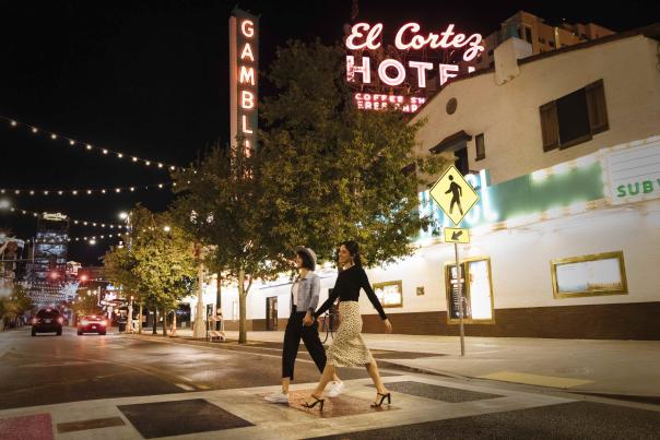Two girls, hand in hand, walking in downtown Las Vegas.