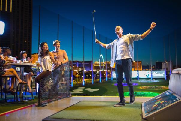 A man basking in the glory of a great swing at TopGolf at MGM Grand in Las Vegas.
