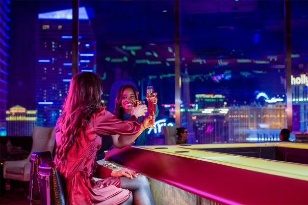 Two women enjoying drinks at the SkyBar at Waldorf Astoria Las Vegas.