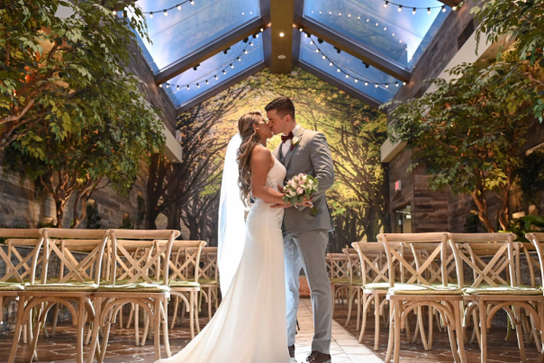 Wedding photo of a newly wed couple kissing at the Glass Garden in Chapel of the Flowers