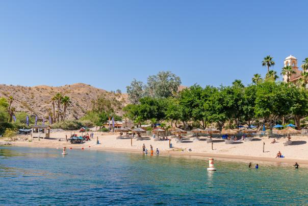 A stunning view of the beach at Harrah's Laughlin with guests enjoying the water.