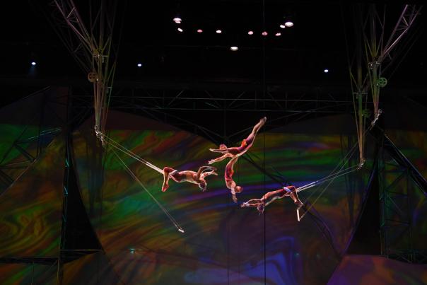A group of performers doing trapeze on stage during the Mystere show by Cirque du Soleil.