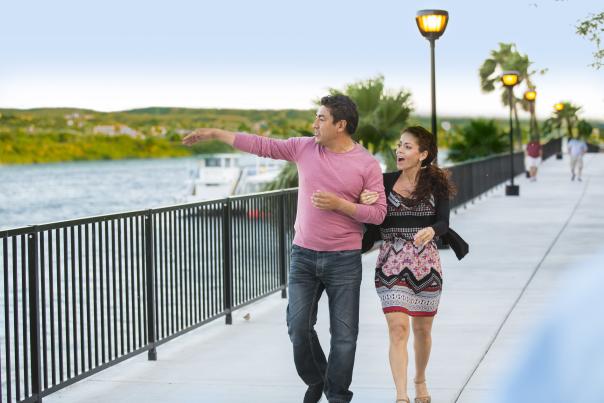 A couple walking along the Laughlin Riverwalk