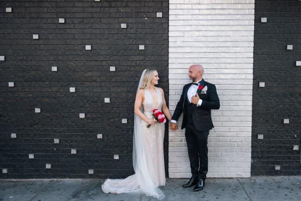 Couple posing in front of a black and white wall for wedding