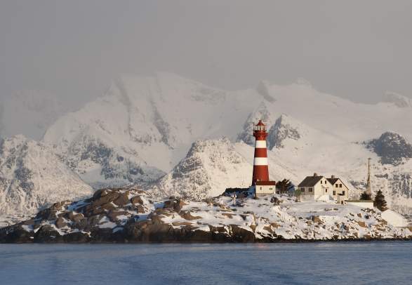 View on the Skrova lighthouse and the snowy mountains, Skrova, Northern Norway from the sea