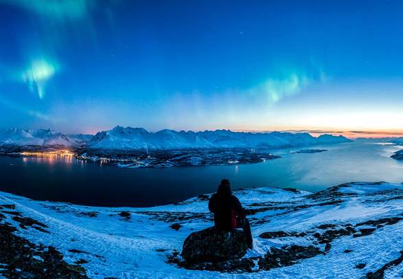 Person watching the northern lights over the Lyngen alps