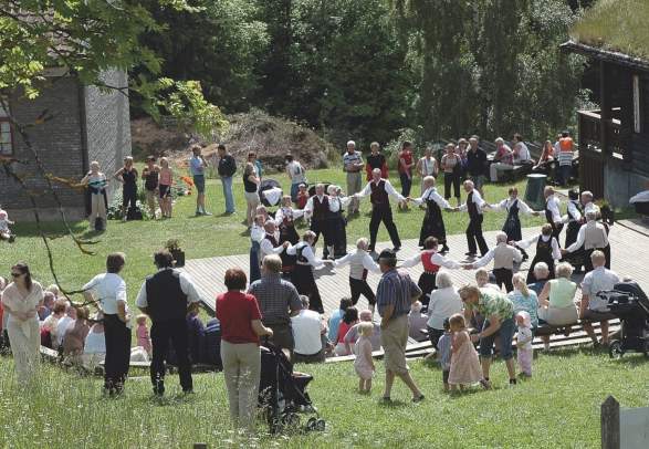 A group of people dancing Norwegian folk dance at Hadeland Folkemuseum