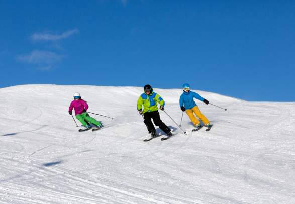 3 downhill skiers in the piste in Geilo