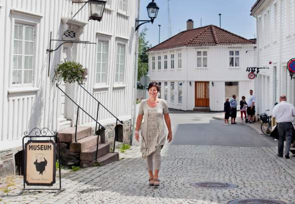 En kvinne går utenfor Ibsen-museet i Grimstad, Sørlandet, Norge.