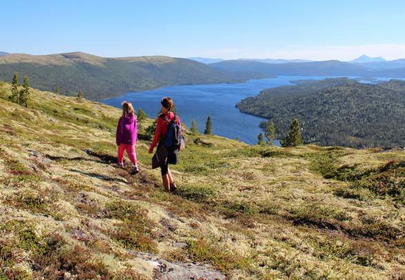 Two people hiking in the mountain terrain at Savalen
