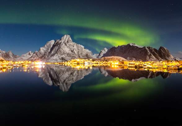 The northern lights over the fishing village Reine in Lofoten, Northern Norway