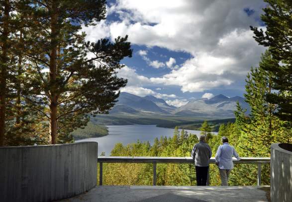 Two people admiring the view from Sohlbergplassen viewpoint on Norwegian Scenic Route Rondane in Eastern Norway