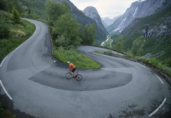 A person road cycling up Stalheimskleiva in Voss in Fjord Norway, one of Norway’s toughest uphill bike routes
