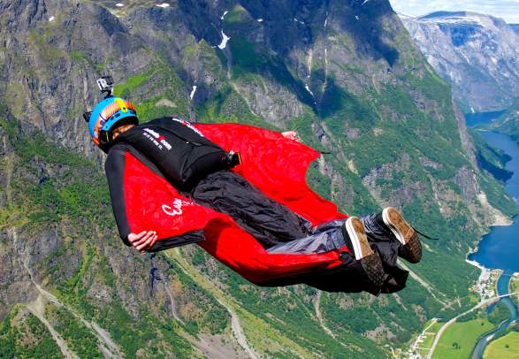 A person BASE jumping with a wingsuit in Voss in Fjord Norway