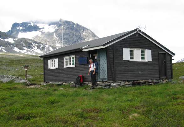 A tourist standing in front of Reinsvassbu cottage, Sunndal