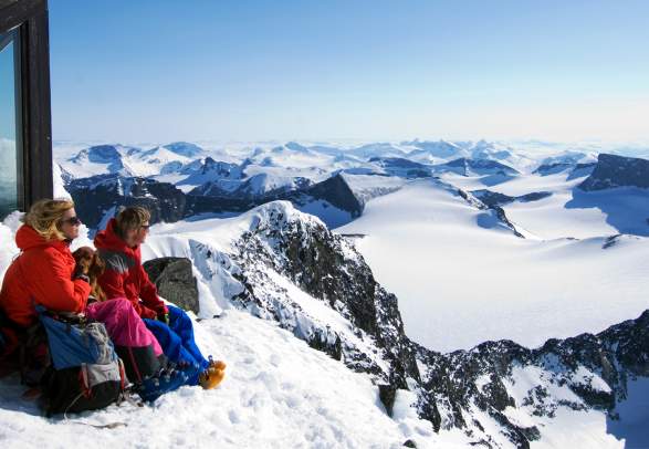Two people admiring the view from Galdhøpiggen in Jotunheimen in winter