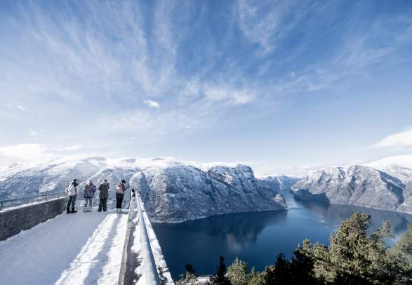 People admiring the view of the Aurlandsfjord from Stegastein viewpoint on Norwegian Scenic Route Aurlandsfjellet in Fjord Norway