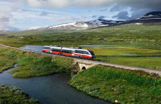 Et tog passerer en innsjø på Saltfjellet i Nordland