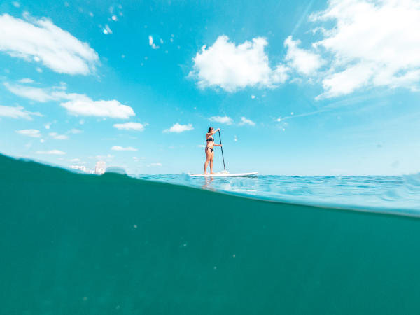 A woman stand-up paddleboarding on the ocean in Fort Lauderdale, FL