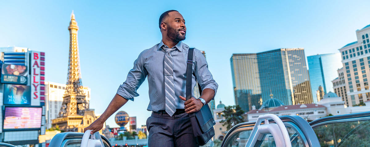 man in business attire at top of escalator in Las Vegas