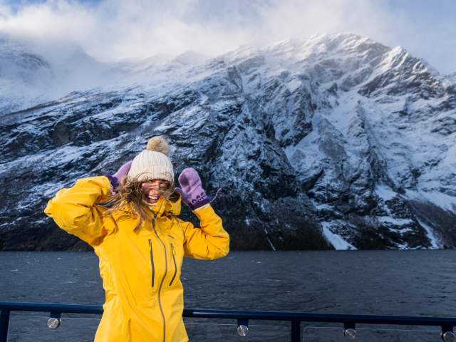 Woman on top of the sightseeing boat from Ålesund to the Geirangerfjord in winter