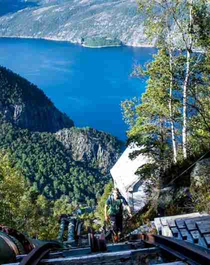 A man climbing up the Flørli staircase above the Lysefjord in Rogaland, Norway