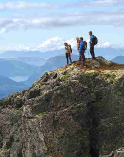 A group of people admire the view from Romsdalseggen in Norway