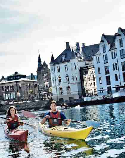 To personer padler kajakk i fjorden utenfor Ålesund
