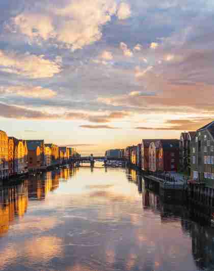 Sunset over the old wooden houses along the Nidelven river in Trondheim in Trøndelag, Norway