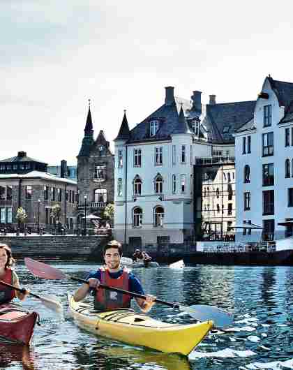 Two people kayaking in the fjord city Ålesund, Norway